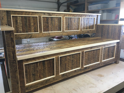 This picture shows the entry bench prior to delivery. The bench was made with reclaimed wood and features a four panel design.