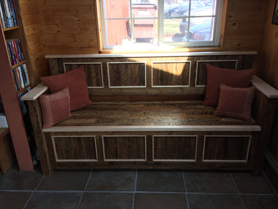 Entry way bench created using reclaimed pine and trimmed with maple. This picture shows the trunk with some throw pillows after final installation. 
