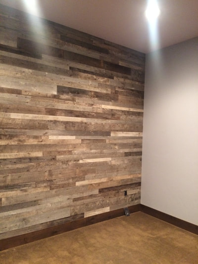 This picture shows the right side of the feature wall made using gray reclaimed wood.