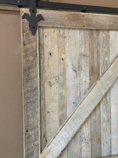 Close up view of the gray  reclaimed wood sliding door. This picture shows a close up one of the diagnol pieces that make up the double z pattern. Also shows the boards behind.
