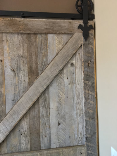 Close up view of the gray  reclaimed wood sliding door. This picture shows a close up one of the top diagnol piece that makes up the double z pattern. 