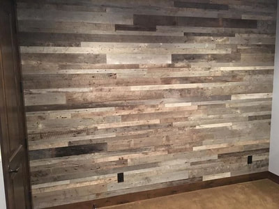 This picture shows the left side of the feature wall made using gray reclaimed wood.