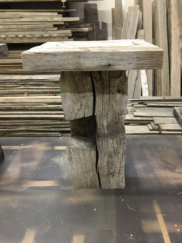This picture shows thee notching in the base of one of the gray hand hewn side tables.