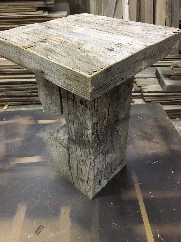 This picture shows the top and the notching in the base of one of the gray hand hewn side tables.