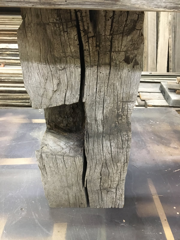 This picture shows the notching in the base of one of the gray hand hewn side tables.