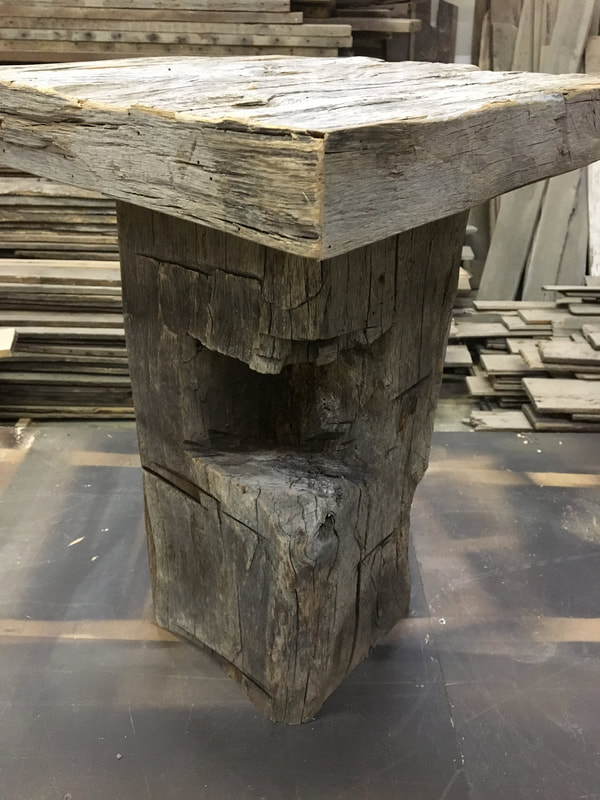 This picture shows the notching in the base of one of the gray hand hewn side tables.