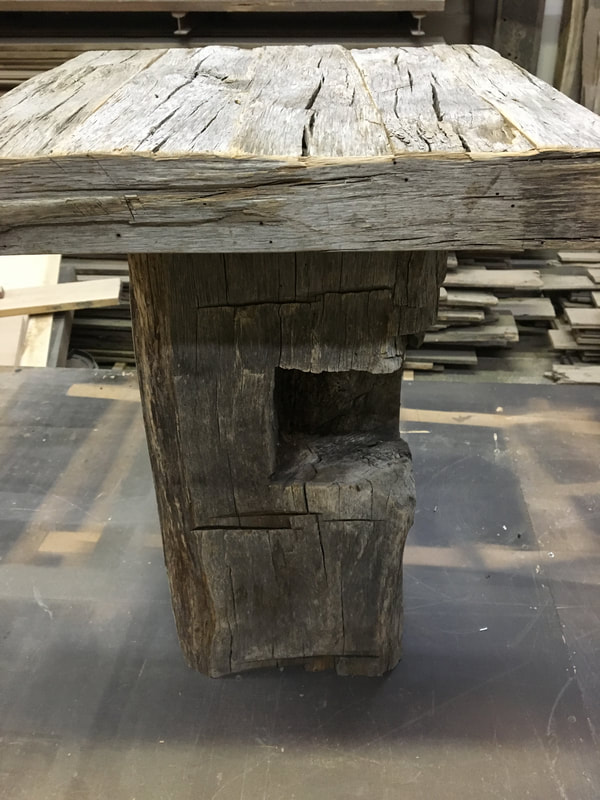 This picture shows the top and the notching in the base of one of the gray hand hewn side tables.