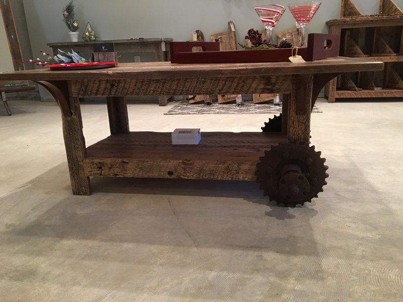 View of the reclaimed wood coffe table showing the antique cogs and rusty corbels.