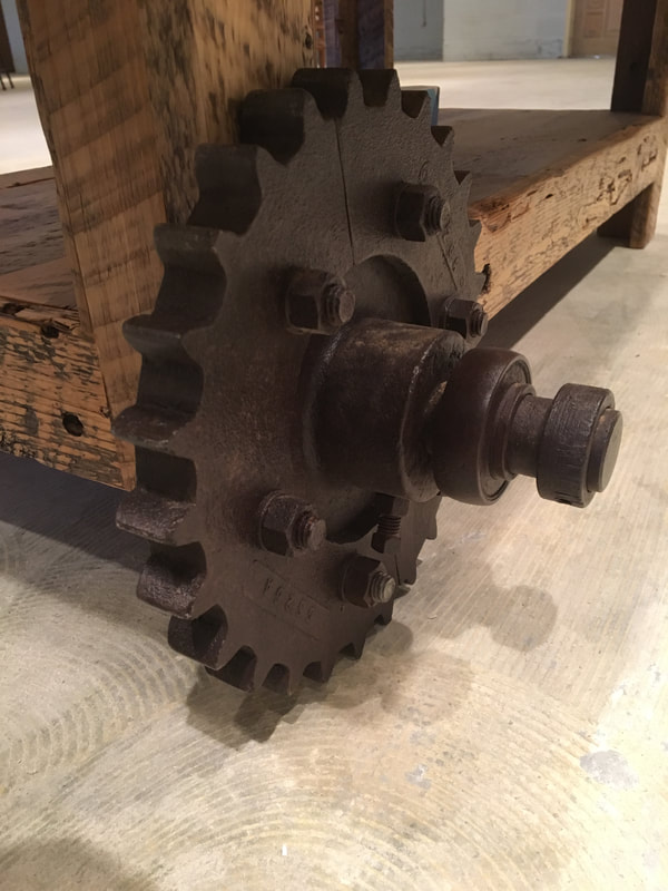Close up view of the antique cog on the reclaimed wood coffee table.